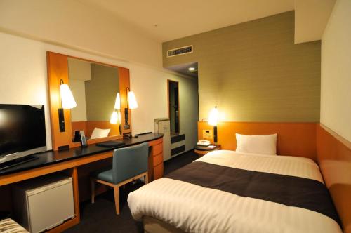 a hotel room with two beds and a television at Hotel Listel Shinjuku in Tokyo