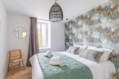 een slaapkamer met een groot bed en een groene deken bij Sieck - Joli Appartement Vue mer in Carantec