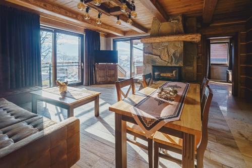 a dining room with a table and a fireplace at TatrApart in Zakopane