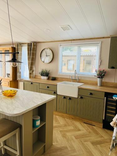 a kitchen with a sink and a clock on the wall at Barakah Lodge with Hot Tub in York