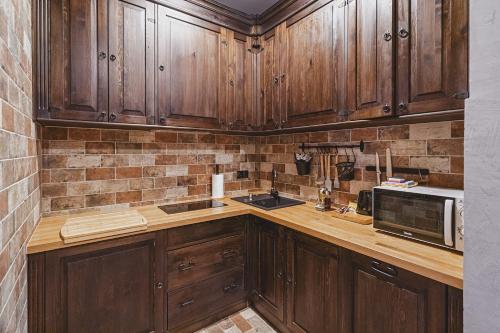 a kitchen with wooden cabinets and a microwave at TatrApart in Zakopane