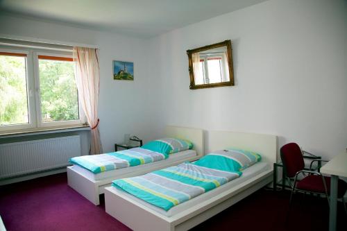 1 dormitorio con 2 camas y espejo en la pared en Hotel Hoffmann, en Essen