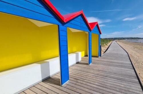 a colorful building on a boardwalk on the beach at 4 bedroom home by the sea in Cork