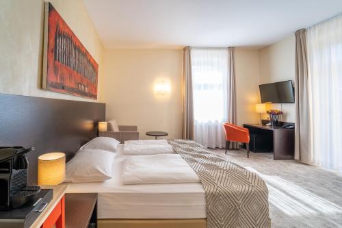 a hotel room with a bed and a desk at Galerie Hotel in Bad Reichenhall