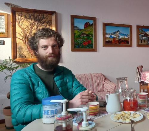 a man with a beard sitting at a table at Bed & Breakfast Barba Bertu in Frassino
