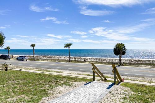 a bench on the side of a road near the ocean at Isle of View in Mexico Beach