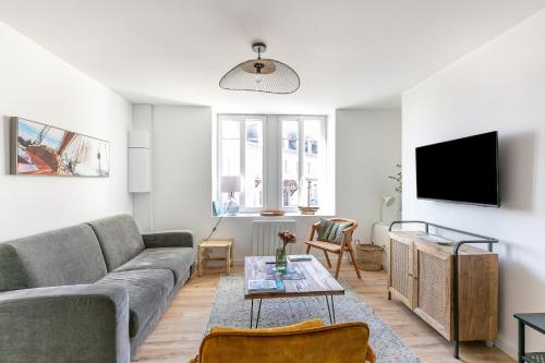 a living room with a couch and a tv at Callot in Carantec