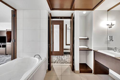 La salle de bains est pourvue d'une baignoire et d'un lavabo. dans l'établissement Hotel Mortagne, à Boucherville