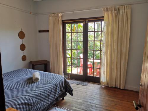 Schlafzimmer mit einem Bett und einer Glasschiebetür in der Unterkunft The Lodge on the Beach in Port St Johns