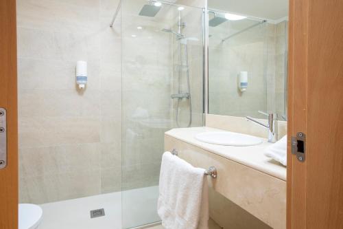 a bathroom with a glass shower and a sink at Sancho Ramirez in Pamplona