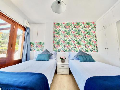 two twin beds in a room with a floral wallpaper at Bollullo Paradise in La Orotava