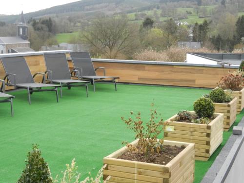 a patio with green grass and chairs on a roof at Le Loft in Stoumont