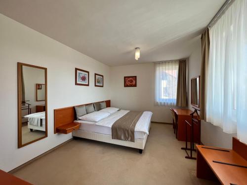a hotel room with a bed and a mirror at Chance Apartman-Birdland Villapark Bükfürdő in Bük