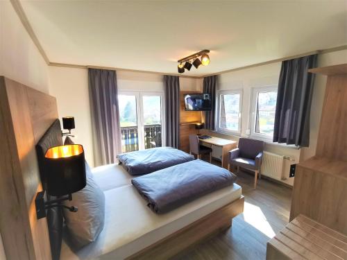 a bedroom with two beds and a desk and a chair at Hotel Grüner Baum mit Restaurant & Wellness in Beerfelden