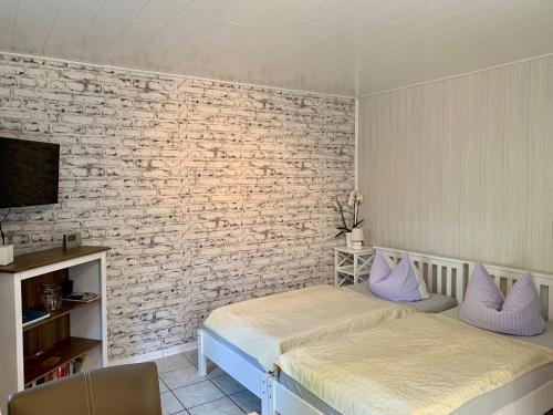 una camera con due letti e un muro di mattoni di 1 Raum Appartement mit Küchenzeile in Kappeln a Kappeln