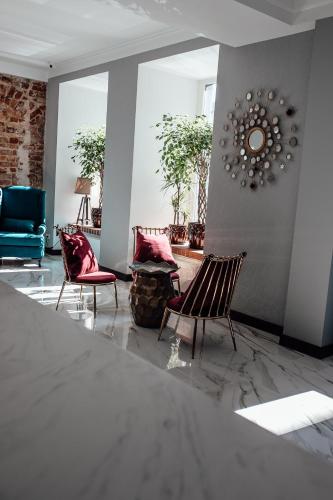 a lobby with two chairs and a clock on the wall at Old Riga Plaza Hotel in Riga
