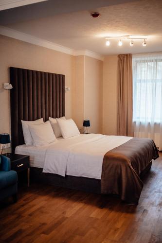 a bedroom with a large bed with white pillows at Old Riga Plaza Hotel in Riga