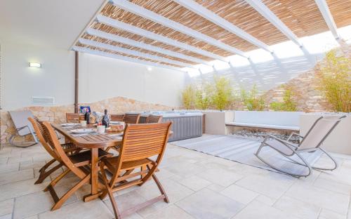 eine Terrasse mit einem Holztisch und Stühlen in der Unterkunft Villa La Tricasina by HDSalento in Tricase