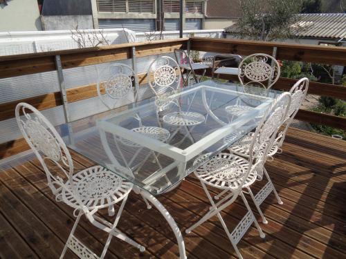 a glass table and chairs on a deck at vacances 34 in Le Crotoy