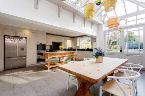 cocina y comedor con mesa de madera y sillas en Veeve - Electric Dreams en Londres