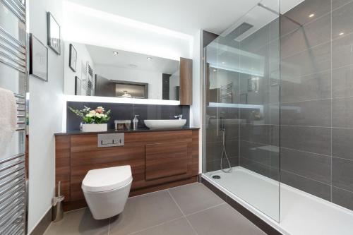 uma casa de banho com um WC e uma cabina de duche em vidro. em Suites by Rehoboth - Darent Court - Dartford Station em Kent