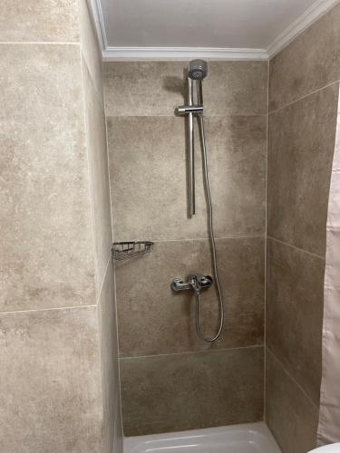 La salle de bains est pourvue d'une douche avec un pommeau de douche. dans l'établissement Alex Beach Apartment 33, à Larnaka
