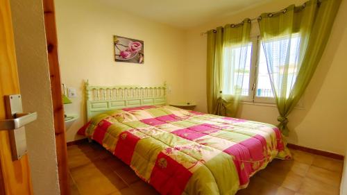 レスカラにあるVACAY Villa Reginaのベッドルーム1室(カラフルな毛布付きのベッド1台付)