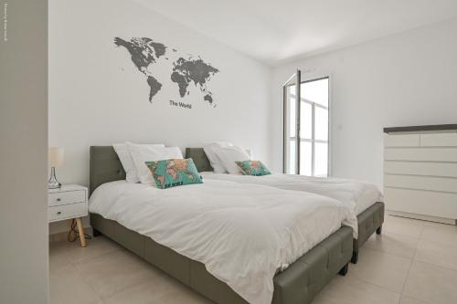 1 dormitorio con 1 cama grande y un mapa mundial en la pared en T3 NEUF – C13 - JARDIN-TERRASSE ET PISCINE – ACCÈS DIRECT PLAGES ET CENTRE VILLAGE, en Saint-Cyr-sur-Mer
