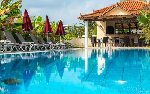 a swimming pool with chairs and umbrellas at California Beach Hotel - Adults Only in Laganas