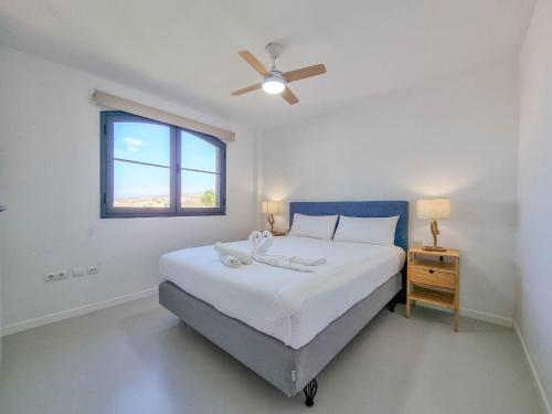 a white bedroom with a bed and a window at Relax in Paraiso in Playa Paraiso