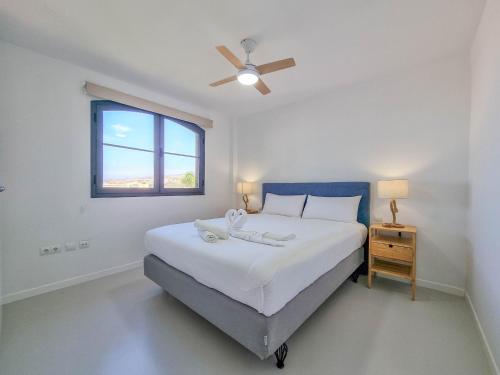 a white bedroom with a bed and a window at Relax in Paraiso by Olax Rentals in Playa Paraiso