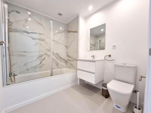 a white bathroom with a shower and a toilet at Relax in Paraiso by Olax Rentals in Playa Paraiso