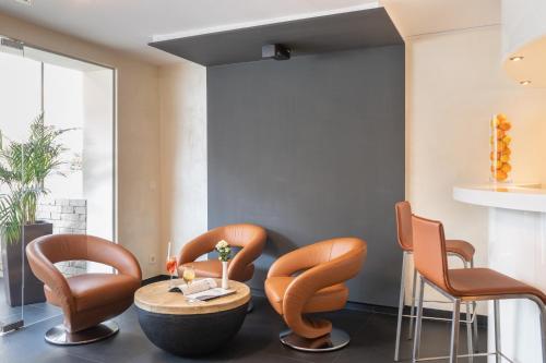 a dining room with orange chairs and a table at Galerie Hotel in Bad Reichenhall