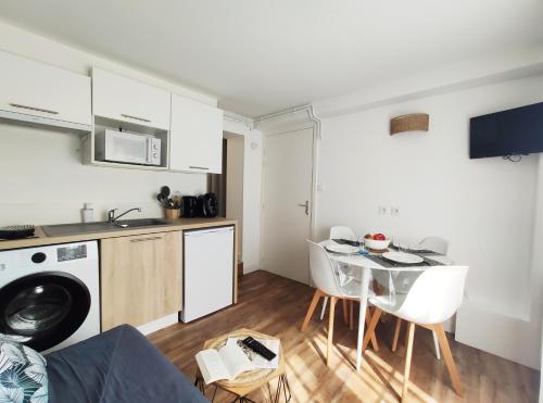 une cuisine et une salle à manger avec une table et des chaises dans l'établissement Charmant T2 proche plage avec terrasse privative, à Royan