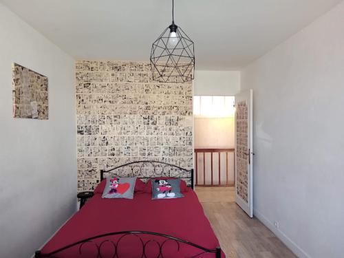 um quarto com uma cama com um edredão vermelho em Appartement le labyrinthe du peintre em Bransat
