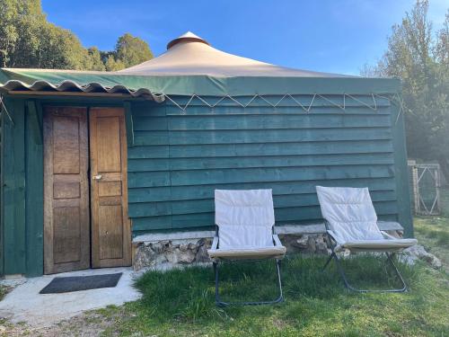 two chairs sitting in front of a green house at Cabane 2 in Olivese