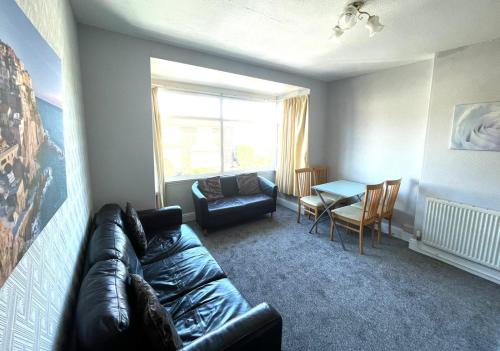 a living room with a leather couch and a table at 2 Bedroom Holiday Apartment Skegness - Flat 18 in Skegness