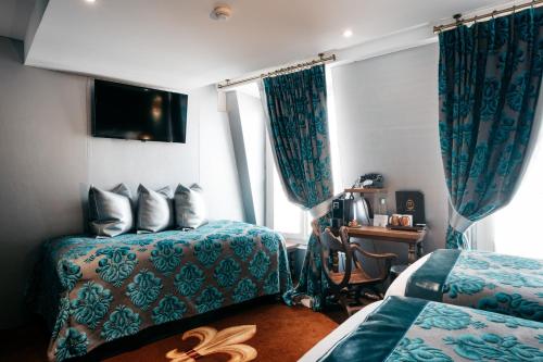 a hotel room with two beds and a window at Le Temple De Jeanne in Paris