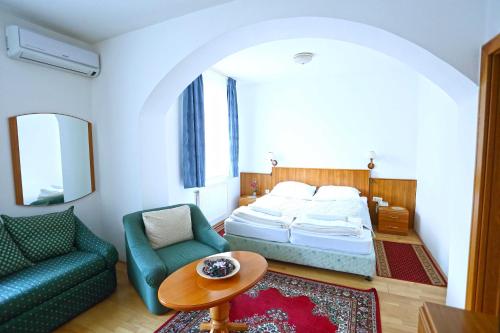 Hotel Wesselényi في جيور: غرفة نوم بسرير واريكة وطاولة