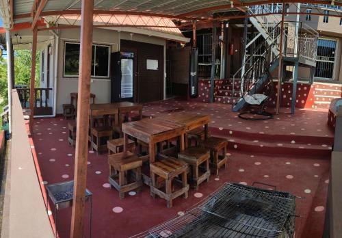 a patio with wooden tables and chairs in a building at Sinurambi 2 in Kundasang