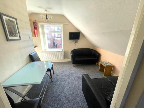 a living room with a black chair and a table at 2 Bedroom Holiday Apartment Skegness - Flat 17 in Skegness