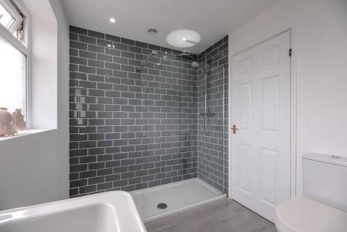 uma casa de banho com uma banheira, um lavatório e um chuveiro em Greenbanks Orford Air Manage Suffolk em Woodbridge