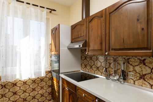 una cocina con armarios de madera y fregadero en Apartments Villa Falkoni, en Dubrovnik