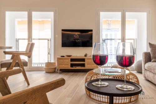 Dos copas de vino tinto en una mesa en una sala de estar en Living4Malaga New Oasis Supreme, en Málaga