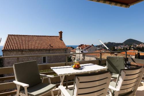 a table and chairs on a balcony with a view at Apartments Villa Falkoni in Dubrovnik