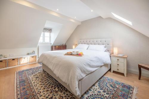 a bedroom with a large white bed and a rug at Little Cottage Wickham Market Air Manage Suffolk in Woodbridge