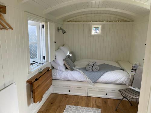 ein kleines Bett in einem Zimmer mit Fenster in der Unterkunft The Hut by the River in York