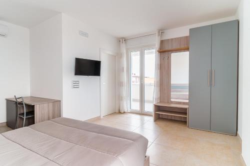 Un dormitorio con una cama, un escritorio y un televisor. en Scaringi Palace A, en Trani