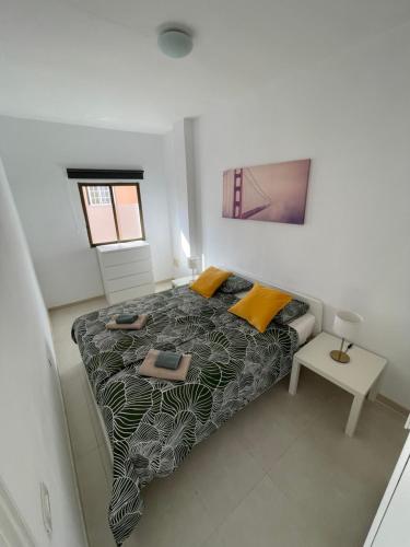 a bedroom with a bed and a table in it at 3BDR Casa El Poris in Poris de Abona