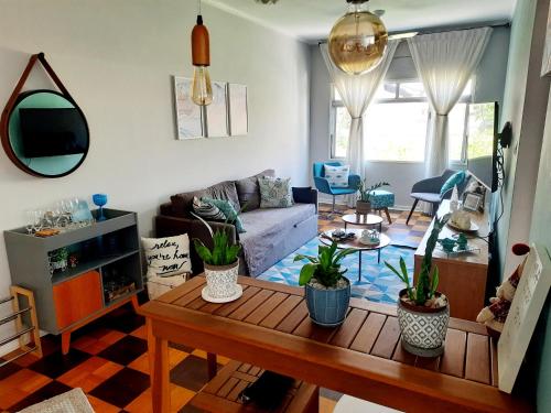 uma sala de estar com um sofá e uma mesa em APARTAMENTO PRAIA GRANDE-CANTO DO FORTE- 2 QUADRAS DA PRAIA WI-FI,NETFLIX e ESTACIONAMENTO na Praia Grande